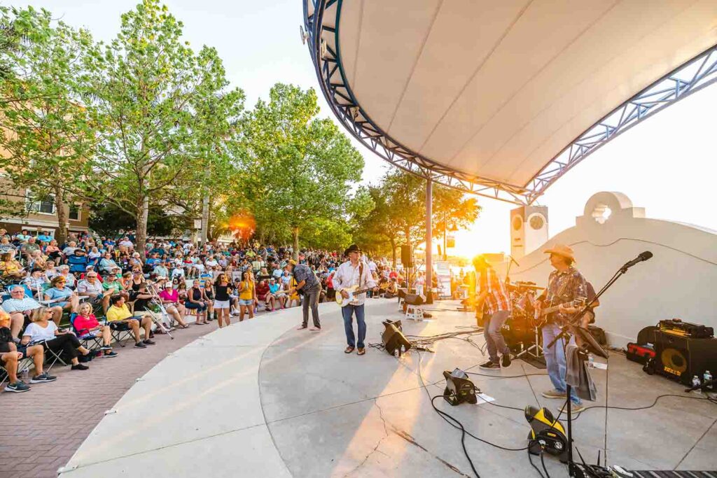 musicians on stage with people sitting at the amphitheater