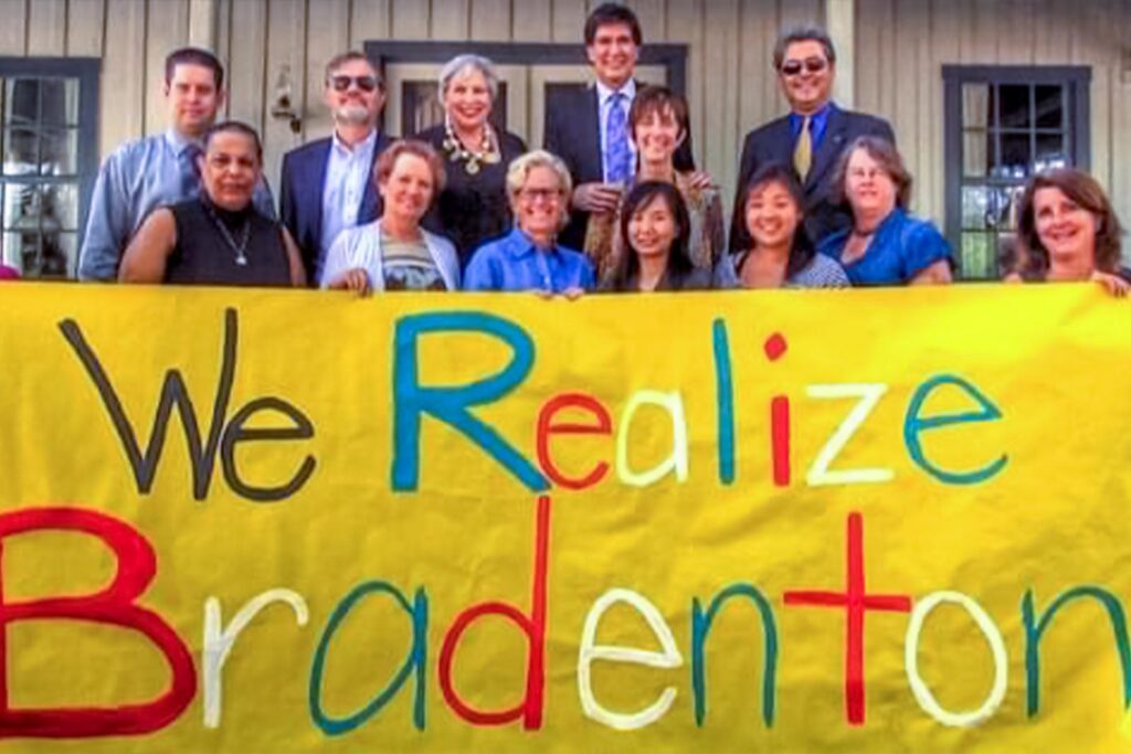 Original Realize Bradenton team holding a banner that says "we Realize Bradenton"