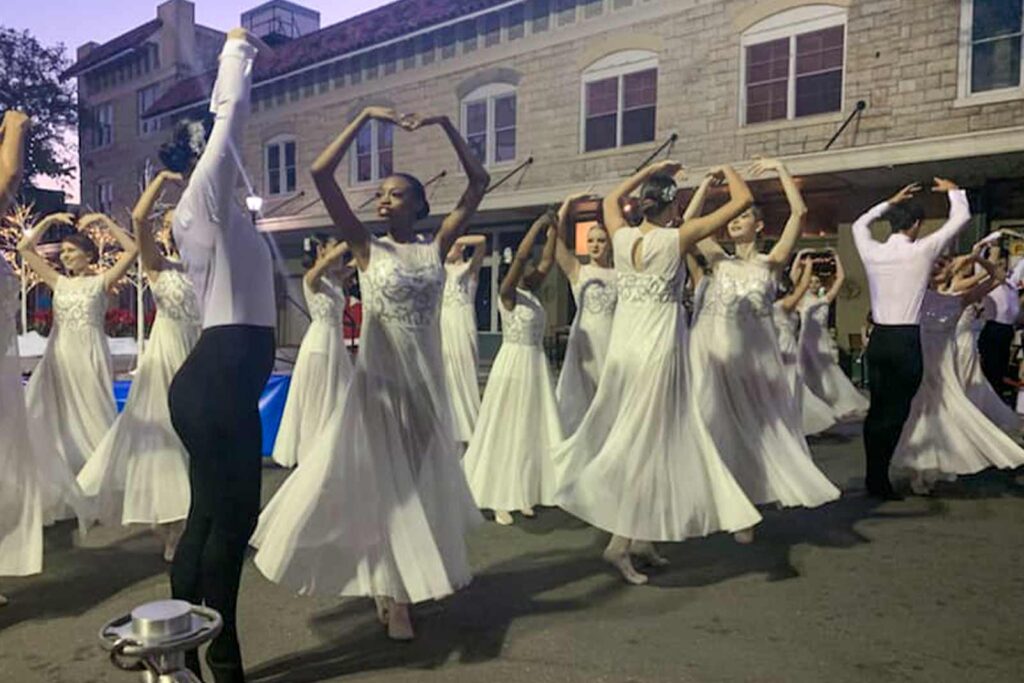 a group of young people dancing together for a winter event