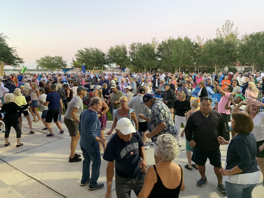 Large crowd dancing outside during Music in the Park