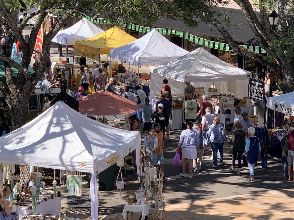 People shop from vendors in their booths at the Bradenton Market